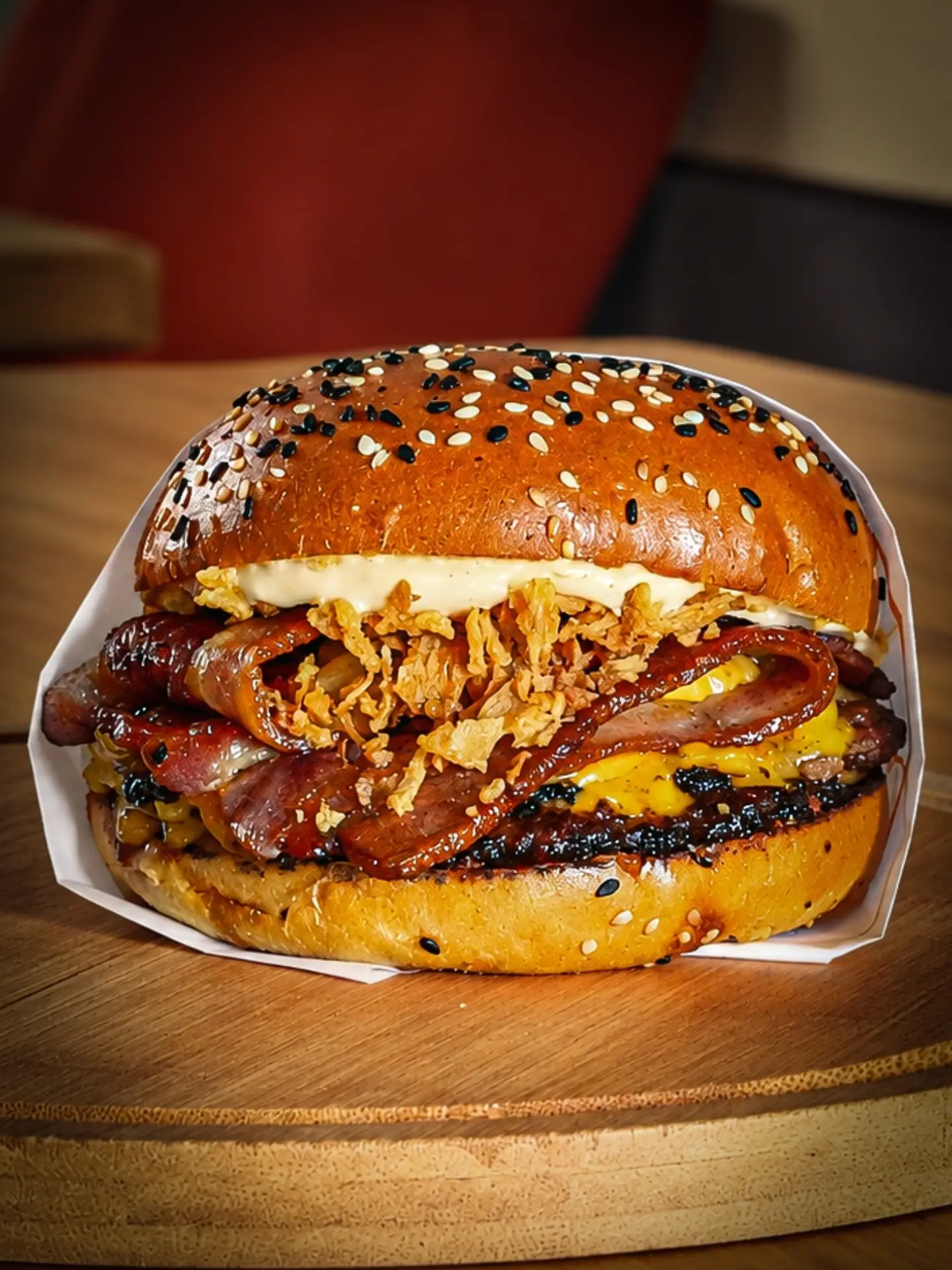 A Mena’s burger photographed on a wooden table