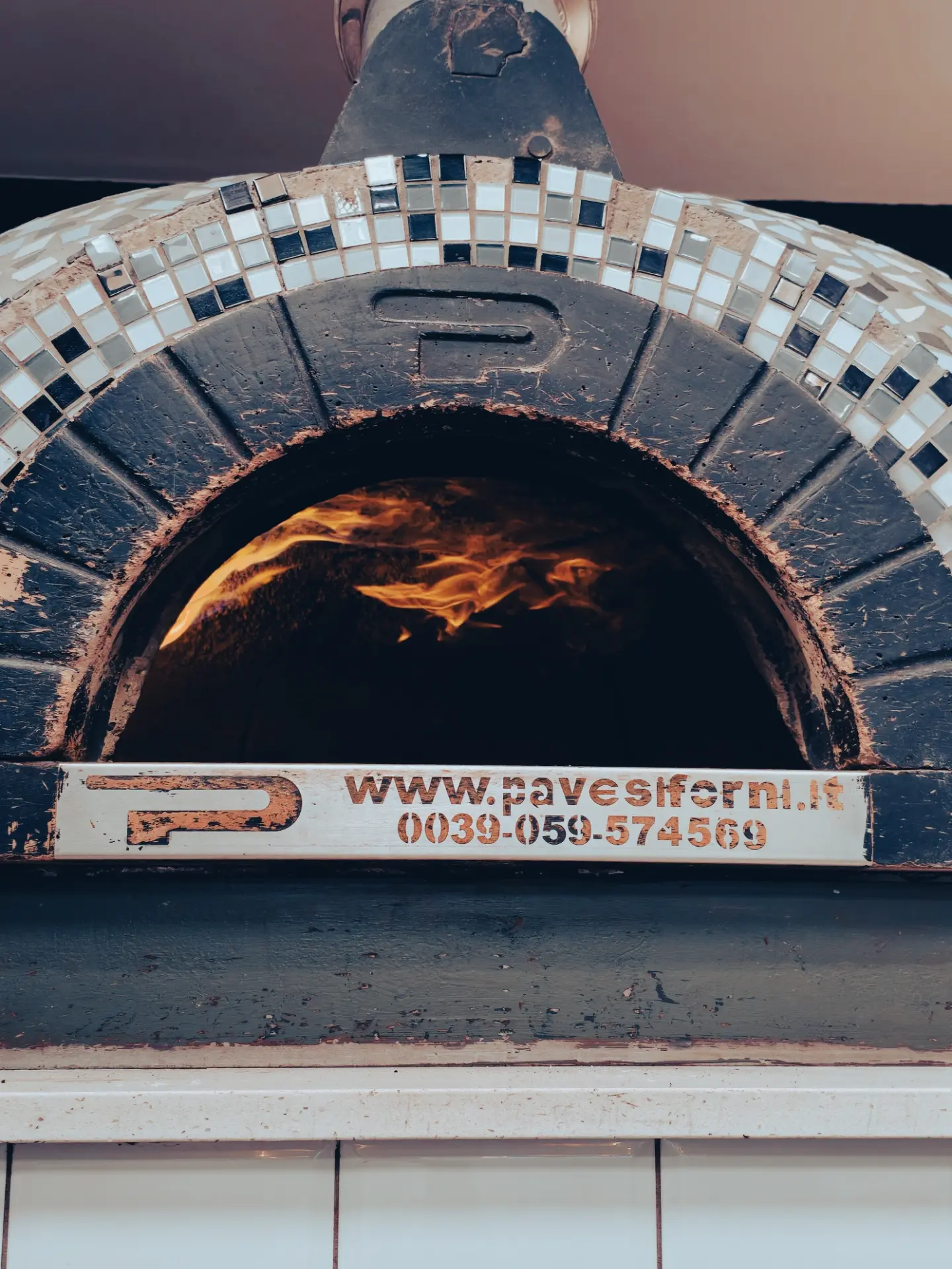 Close view of the tiled pizza oven with a flame inside
